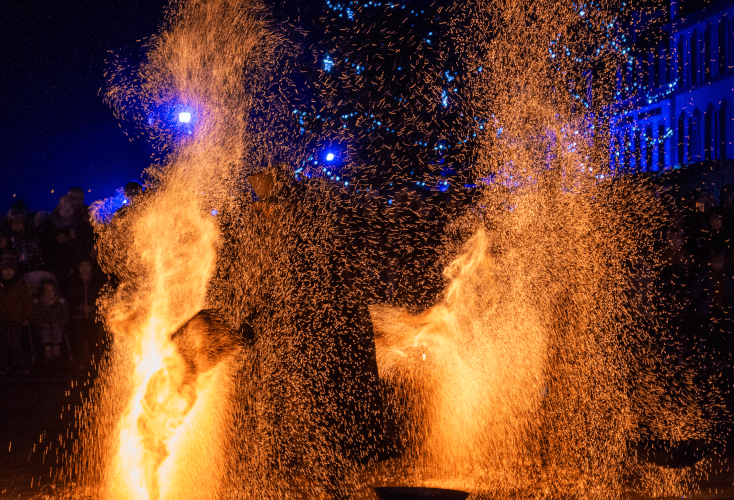 Un spectacle de feu, avec des braises partout qui recouvre une personne (avec des protections).