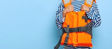Enfant en marinière avec un gilet de sauvetage orange, sur fond bleu.