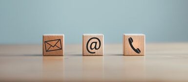 Des cubes de bois avec sur chacun un symbole, une lettre (mail), un arobase, un téléphone.