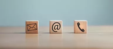 Des cubes de bois avec sur chacun un symbole, une lettre (mail), un arobase, un téléphone.