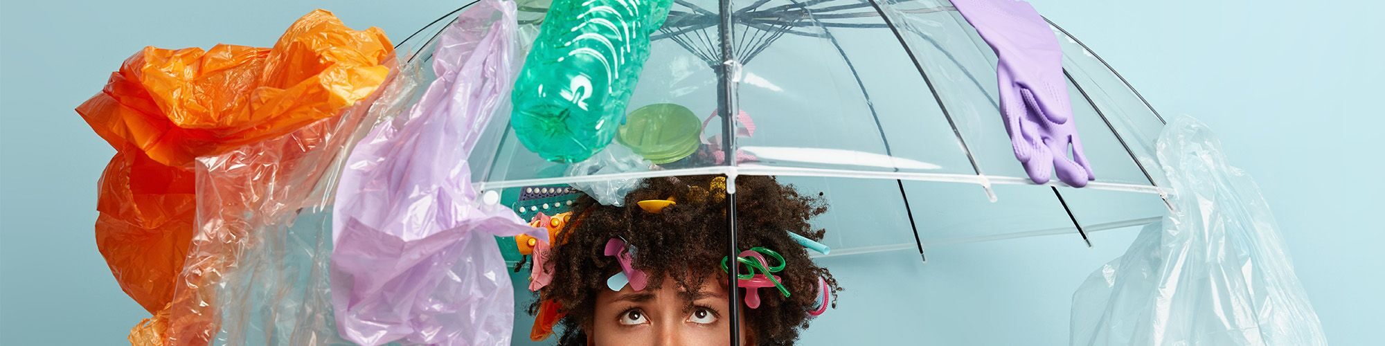 Une femme avec un parapluie recouverte de détritus;