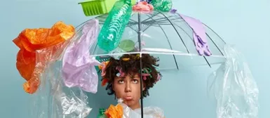 Une femme avec un parapluie recouverte de détritus;