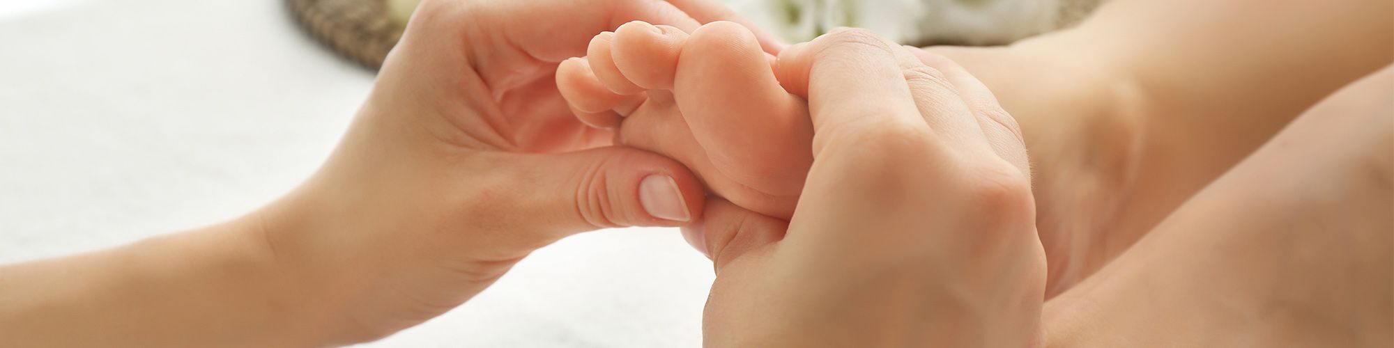 Des mains qui massent le pied d'un enfant.