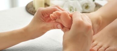 Des mains qui massent le pied d'un enfant.