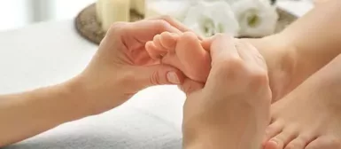 Des mains qui massent le pied d'un enfant.