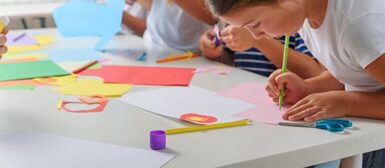 Des enfants qui découpent des feuilles et dessinent.