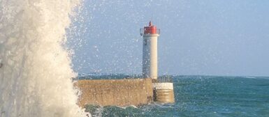 Le feu du Raoulic, avec une grande vague qui passe sur le môle.