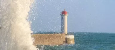 Le feu du Raoulic, avec une grande vague qui passe sur le môle.