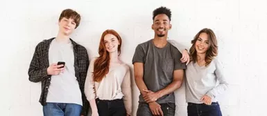 Quatre jeunes souriants, deux garçons et deux filles.