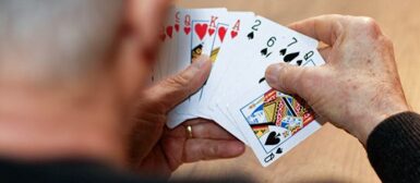 Un homme âgé qui joue aux cartes.