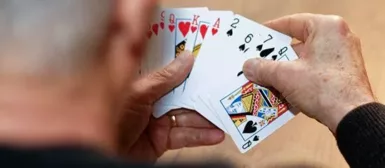 Un homme âgé qui joue aux cartes.
