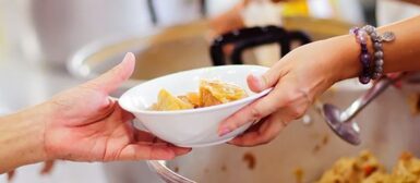 Une personne qui sert un repas à un usager.
