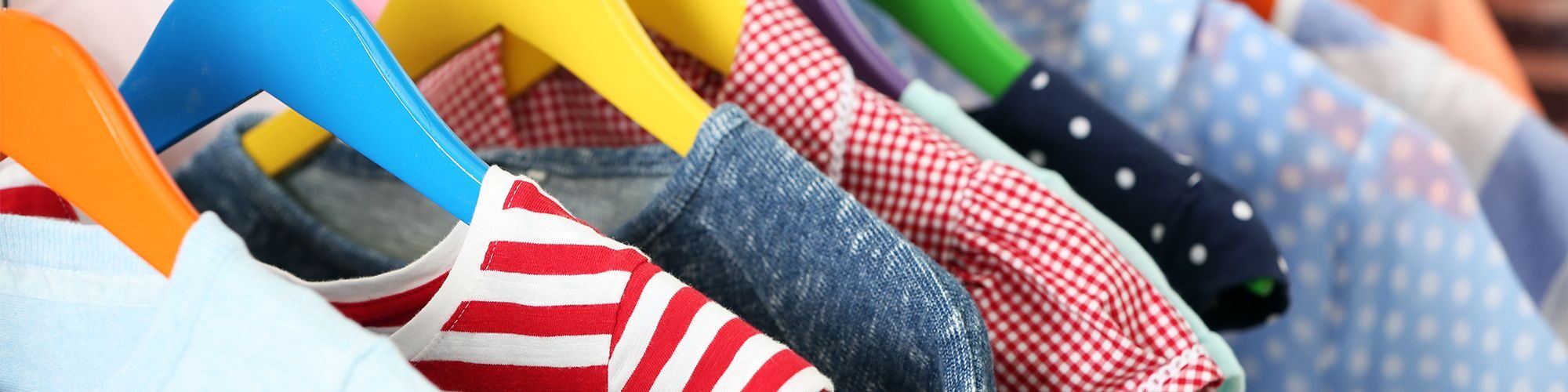 Un vestiaire avec des vêtements sur des cintres.