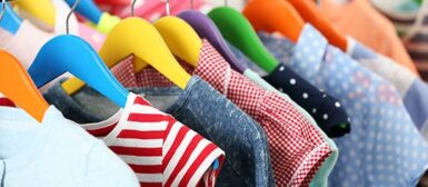 Un vestiaire avec des vêtements sur des cintres.