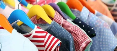 Un vestiaire avec des vêtements sur des cintres.